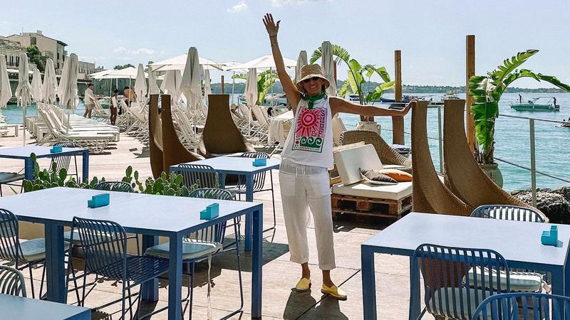 Andrea waving at a seaside beach club